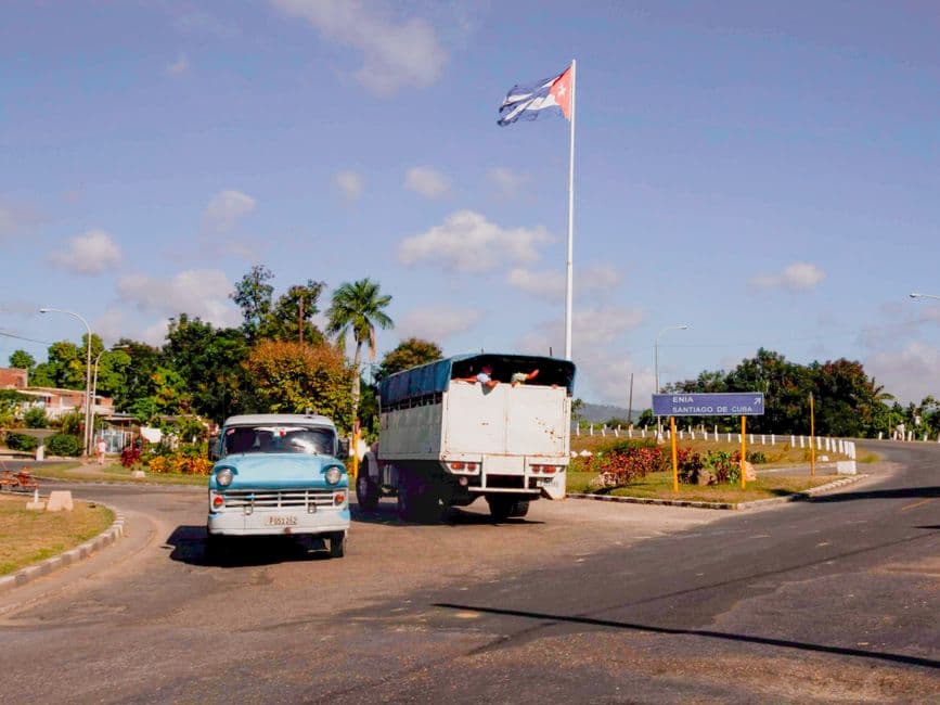 Clásicos automóviles antiguos cerca de una bandera cubana, en la sala de chat de Ciego de Ávila