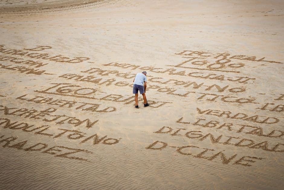 Persona escribiendo sobre la arena, en el chat de Libertad