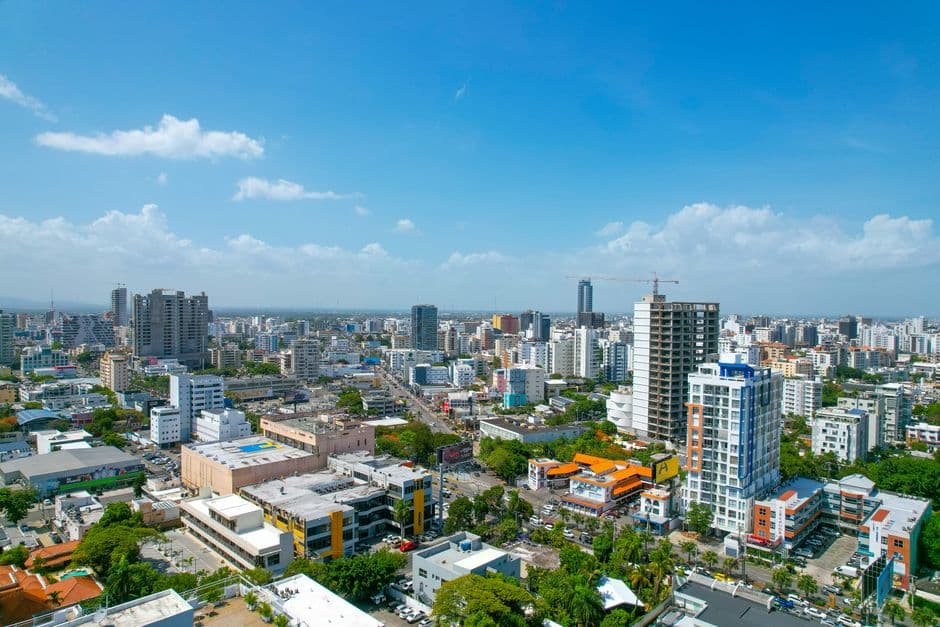Vista aérea de edificios bajo cielo azul, en el chat de Santo Domingo Este