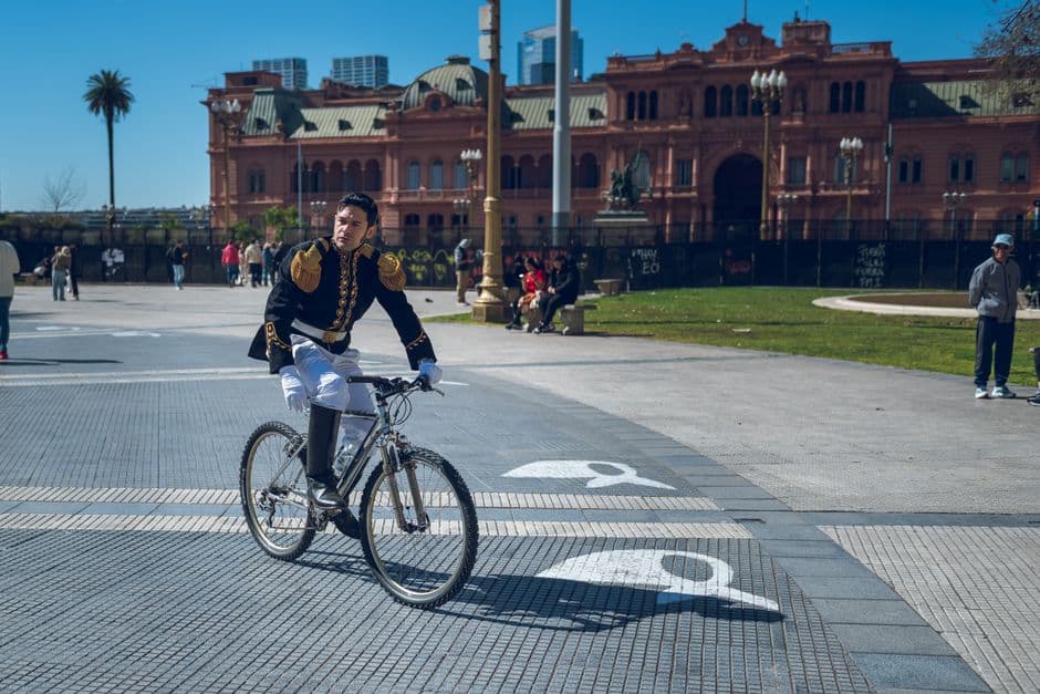 Ciclista con uniforme histórico en una plaza, en el chat de Libertador General San Martín