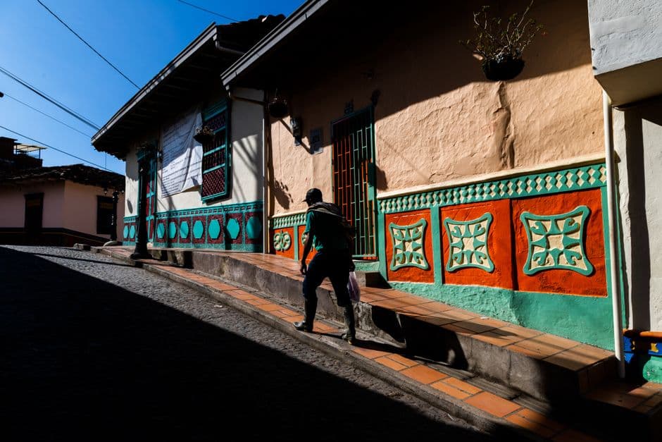 Hombre caminando por la calle entre casas de hormigón, en el chat de Ayapel