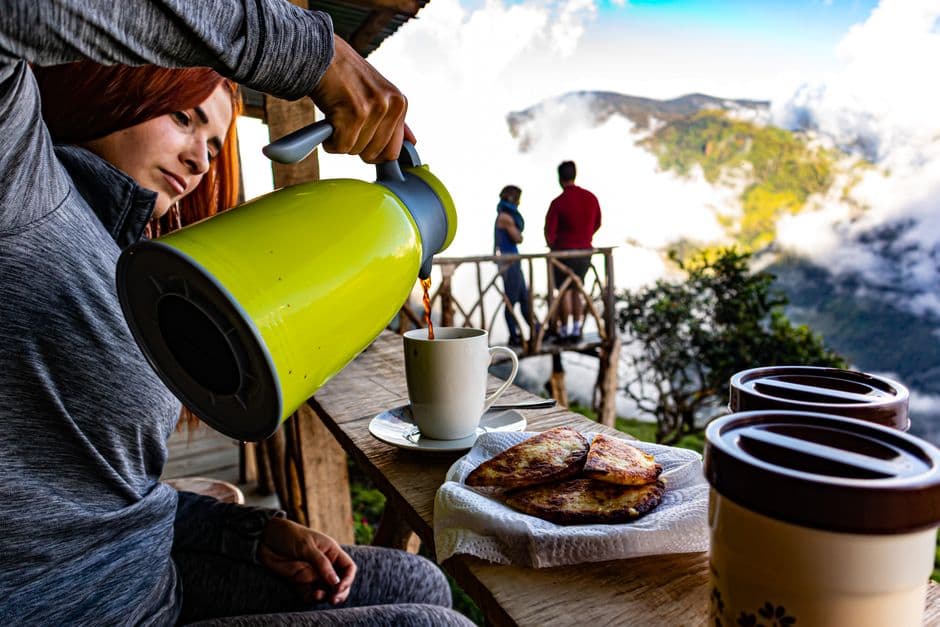 Mujer sirviendo café en una taza blanca en una terraza, en el chat de Quesada