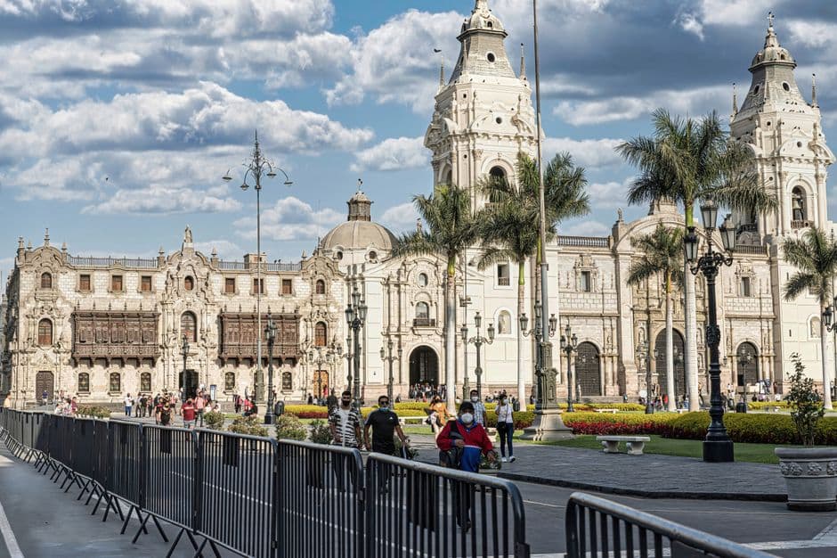 Gente caminando junto a un edificio histórico de estilo gótico, en el chat de Imaza