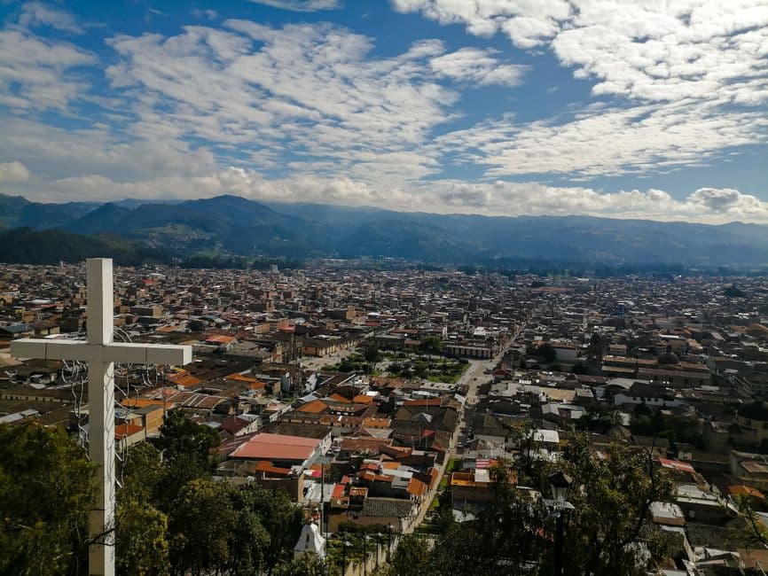 Cruz de madera sobre colinas bajo nubes densas, en el chat de Jacaltenango