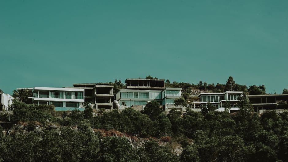 Edificios blancos y grises con árboles verdes bajo cielo verde, en el chat de Villa Hermosa
