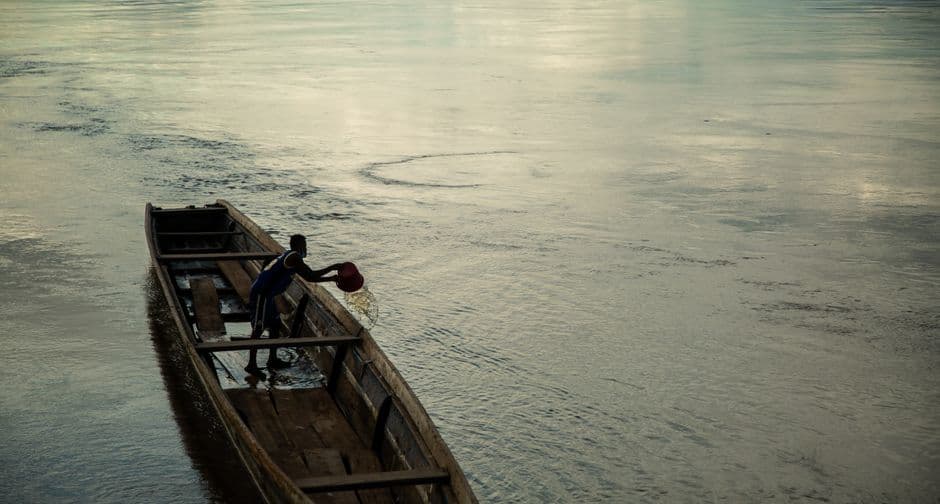 Hombre sacando agua de un bote con filtraciones, en el chat de Cumaribo