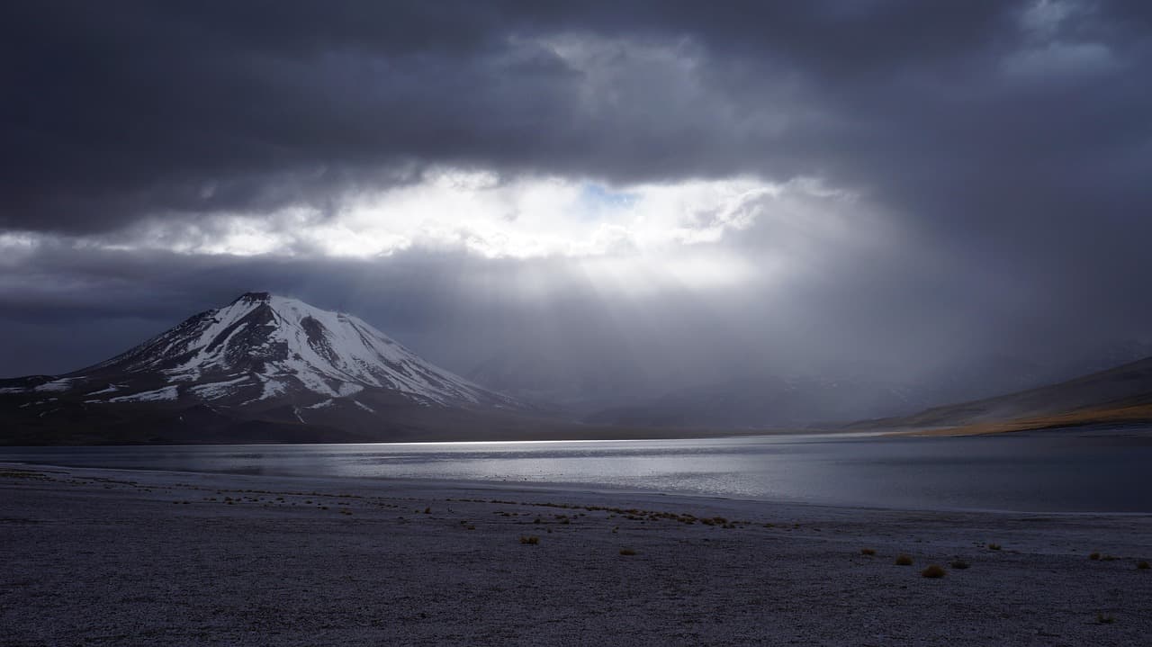 Lago entre montañas nevadas bajo cielo gris, en la sala de chat de San Pedro Nécta