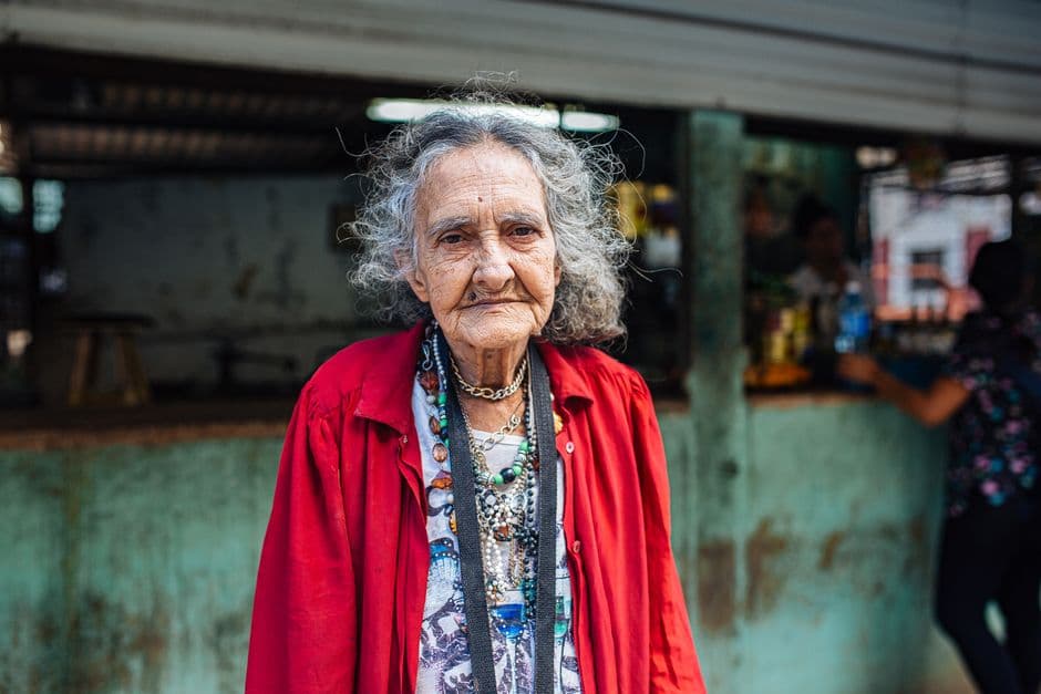 Mujer mayor en una calle llena de color, en el chat de Vieja