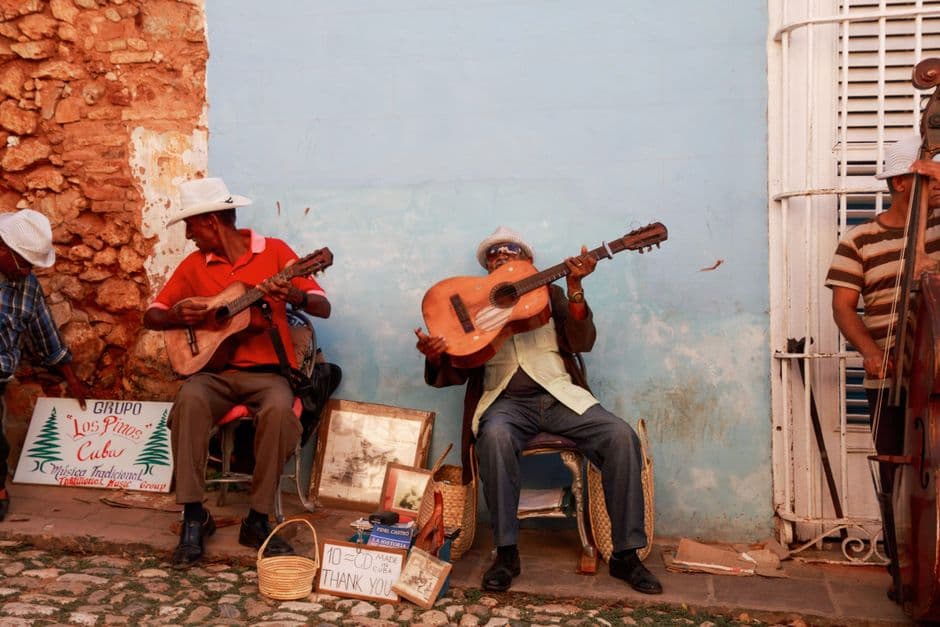 Hombres tocando la guitarra en la calle, en el chat de Caibarién