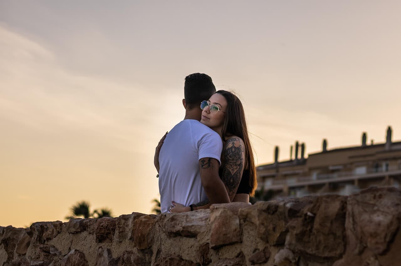Pareja abrazada en la costa al atardecer, en el chat de La Mata