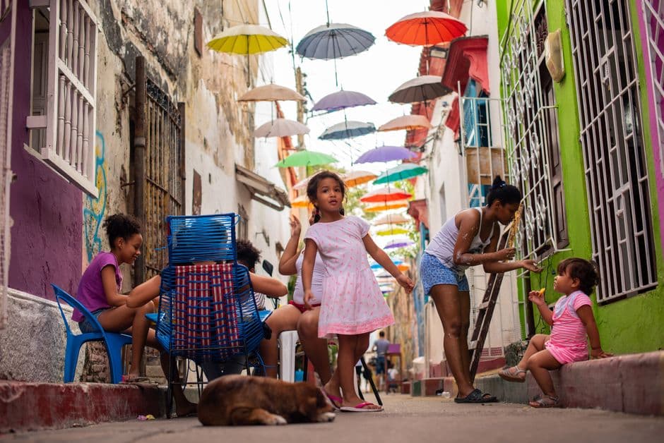 Niña con vestido rosa de pie en un callejón, en el chat de La Macarena