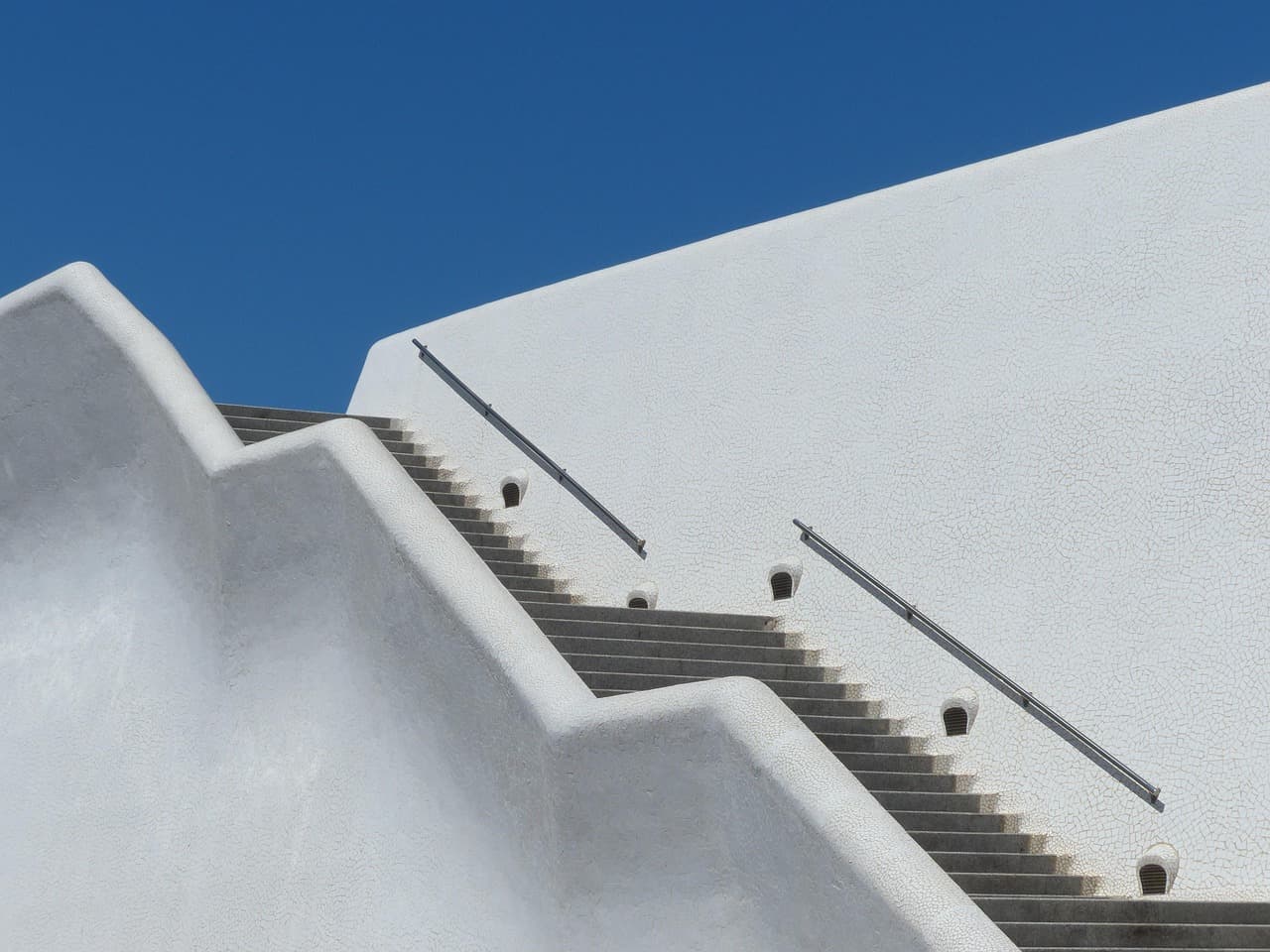 Escalera blanca de varios tramos que asciende, en la sala de chat de Santa Cruz Verapaz