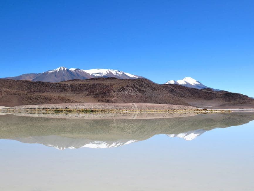 Reflejo de una montaña nevada sobre aguas tranquilas, en el chat de Montero
