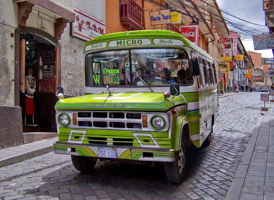 Un autobús verde y blanco circula por la calle, en el chat de Viacha