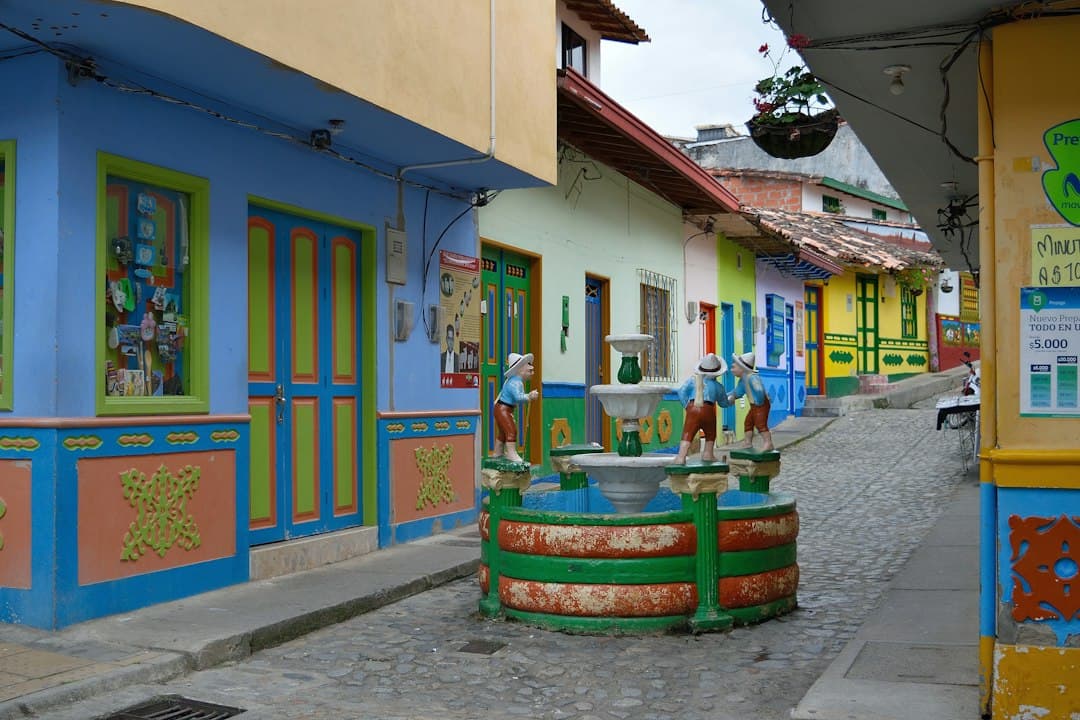 Edificios de colores a lo largo de una calle con una fuente, en el chat de Olaya Herrera