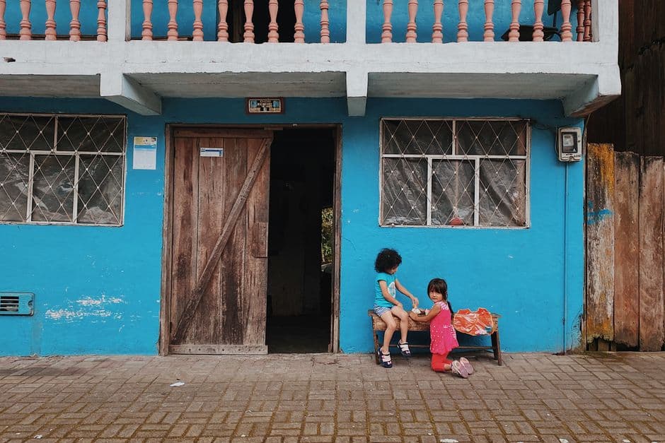 Niños jugando en un banco delante de un edificio, en el chat de Guaranda