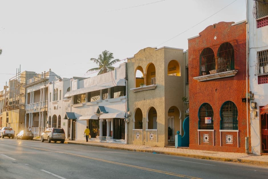Fachadas de casas antiguas de piedra junto a una calle con coches, en el chat de Consuelo