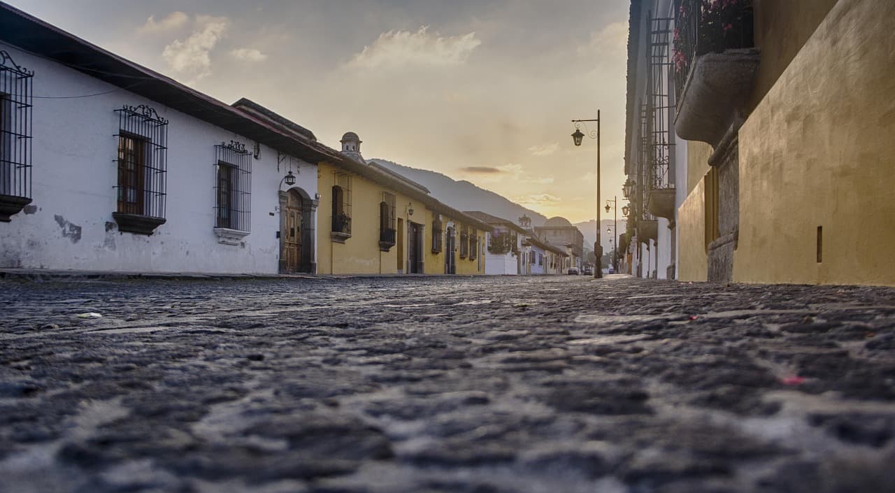Calle con casas coloridas bajo el amanecer dorado, en el chat de Peronia, Villa Nueva, Guatemala