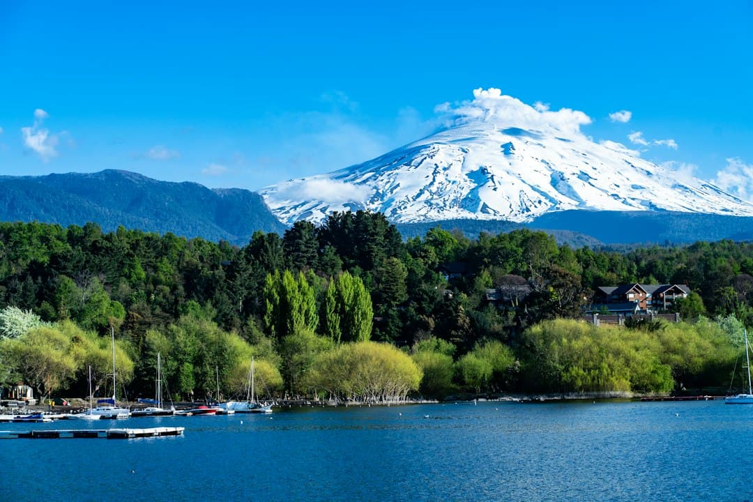 Lago con barcas y una montaña al fondo, en el chat de Pucón