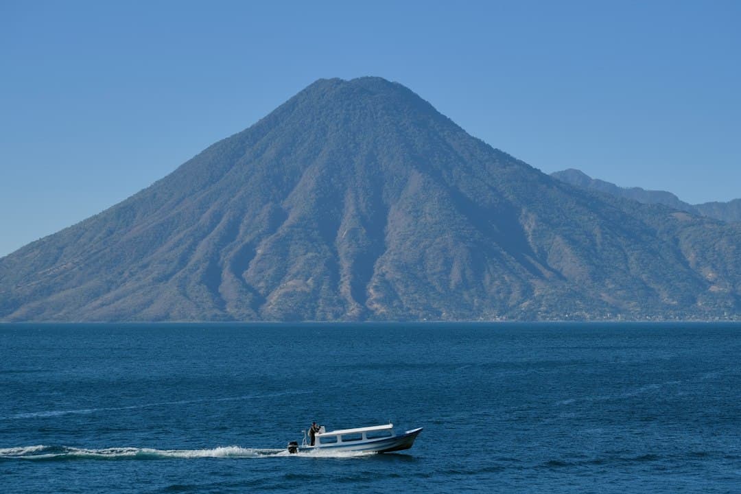 Barca en el agua con una montaña al fondo, en el chat de Guastatoya