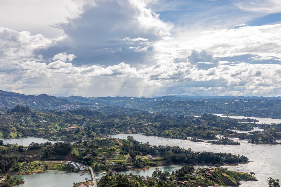 Valle verde con colinas y lagos bajo cielo azul, en la sala de chat de Bello