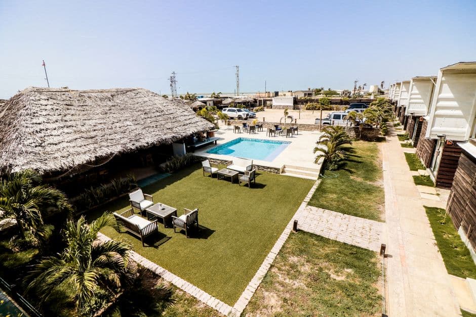 Cabaña de palma y piscina en un complejo turístico, en el chat de Puerto Píritu
