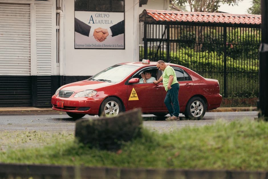 Calle con un taxi rojo en la provincia de Alajuela, en el chat de Atenas