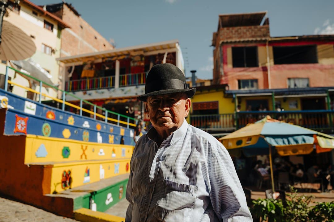 Hombre con sombrero de pie delante de un edificio, en el chat de Roberto Payán