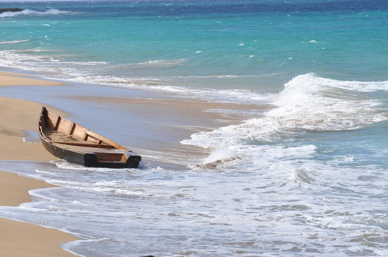 Restos de una barca de madera en una playa, en el chat de Puerto Bermúdez