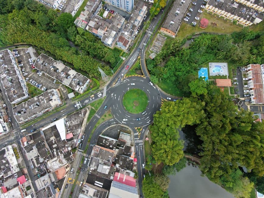 Vista aérea de una rotonda rodeada de árboles y carreteras, en el chat de Dosquebradas