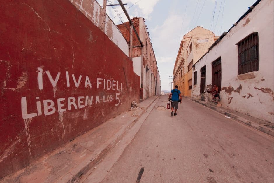 Hombre con camisa azul camina por una carretera de concreto, en el chat de Libertador