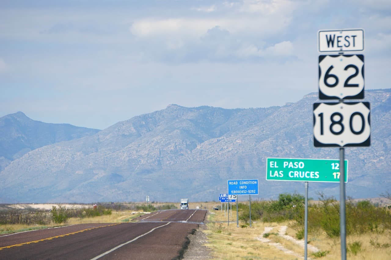 Carretera entre montañas con una señal de tráfico, en el chat de El Paso