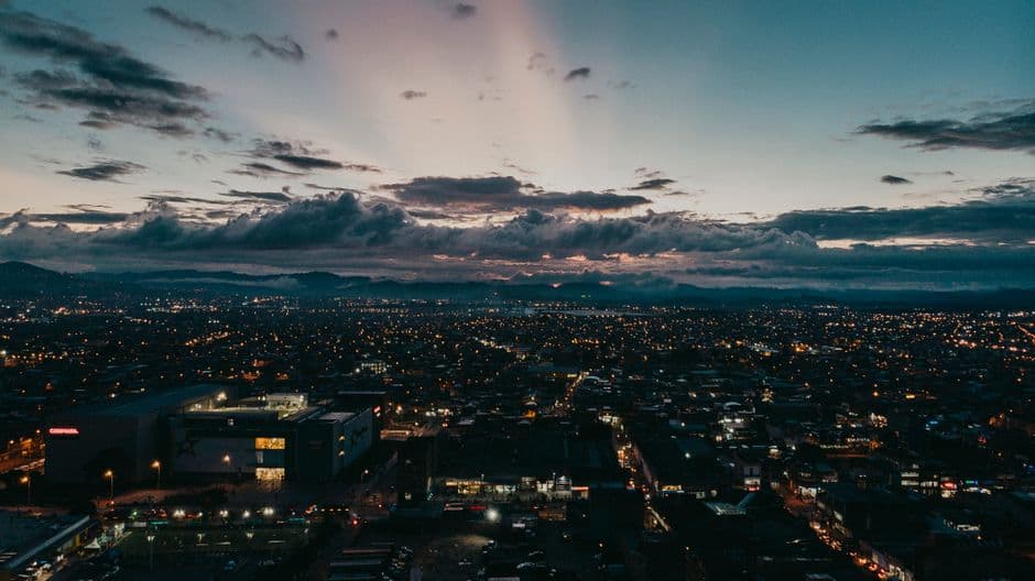 Ciudad al atardecer con edificios y montañas, en la sala de chat de Piedecuesta