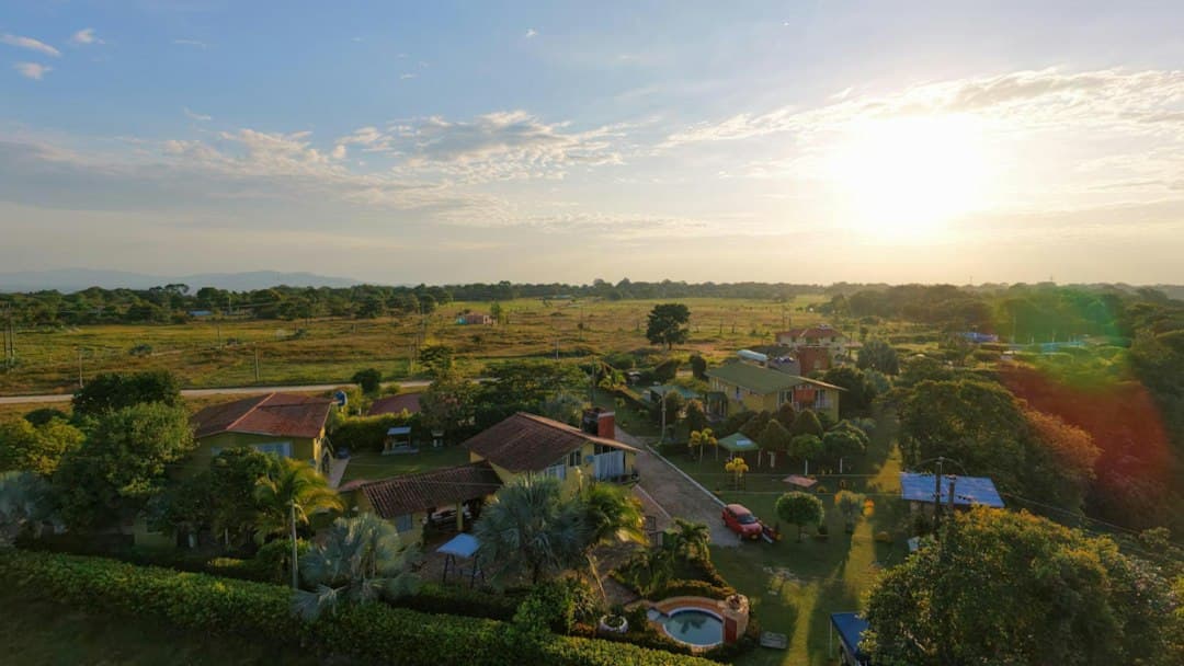 Vista aérea de casas y campos al atardecer, en el chat de Curumaní