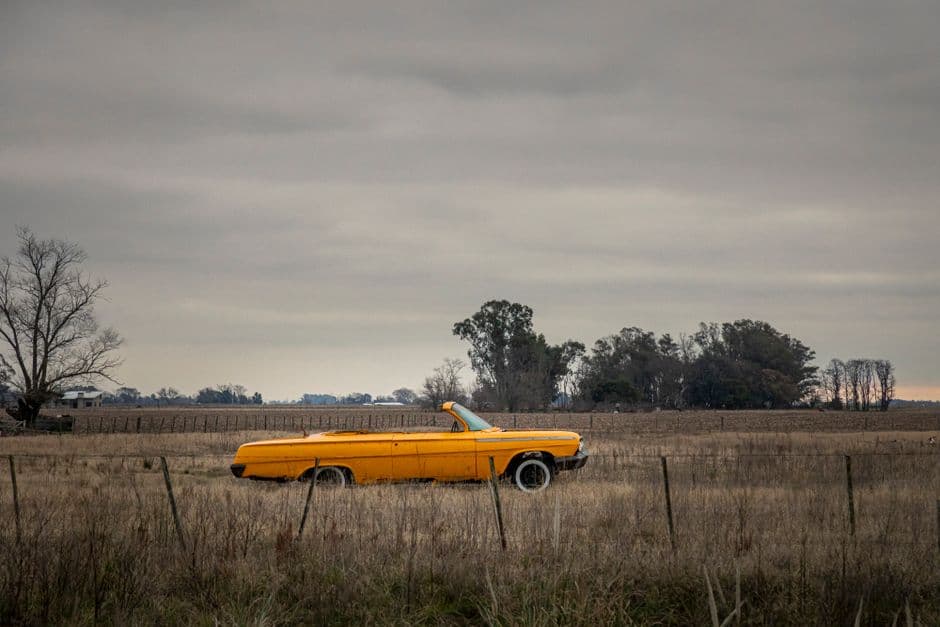 Coche antiguo amarillo en un campo argentino al atardecer, en el chat de Saavedra