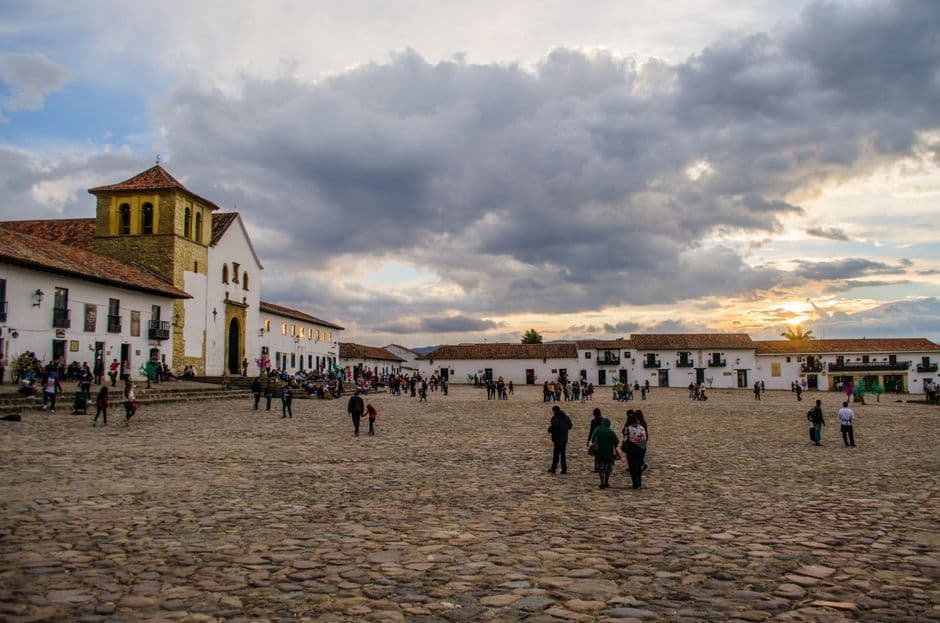 Gente en la plaza de un pueblo al atardecer, en el chat de Villa de Leyva