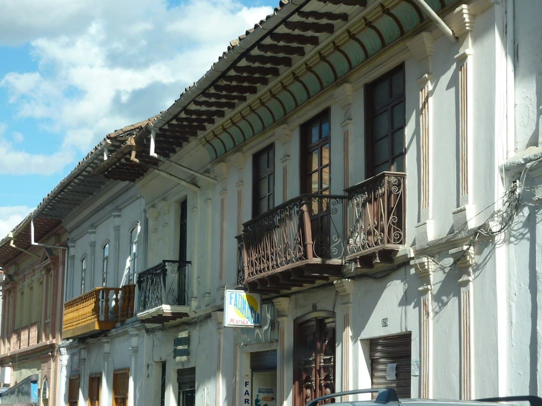 Edificio de hormigón blanco y marrón bajo nubes blancas, en el chat de Gualaquiza