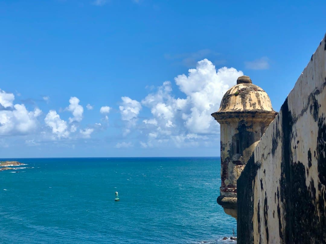 Edificio de hormigón marrón junto al mar bajo un cielo con nubes, en el chat de Santa Isabel