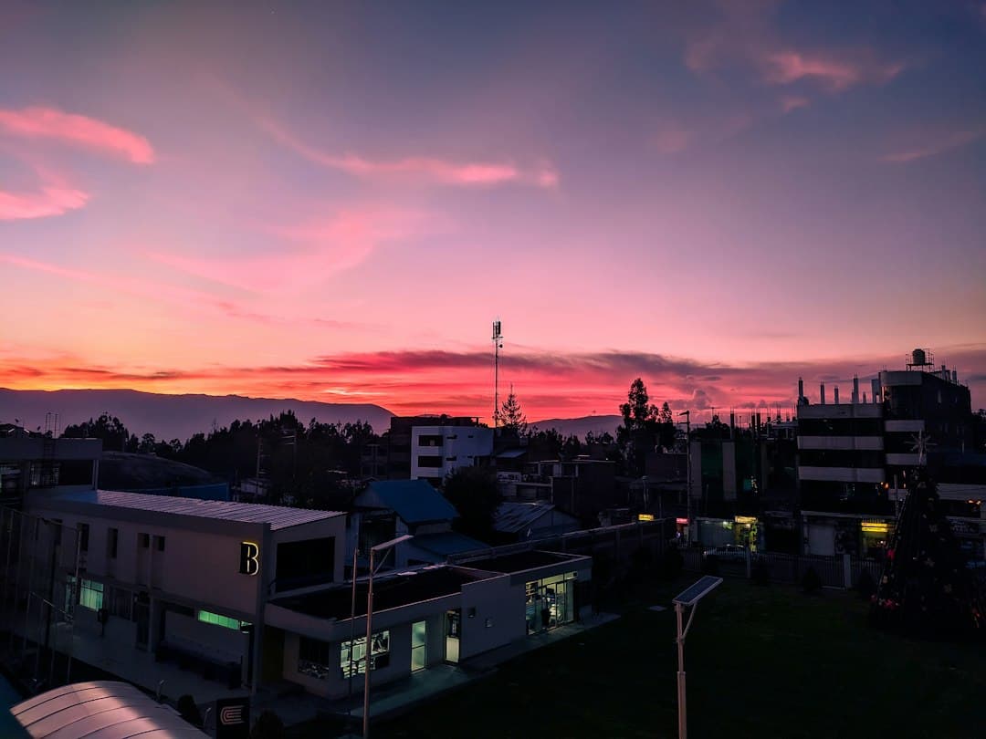 Atardecer sobre una ciudad con edificios en primer plano, en el chat de Pilcomayo
