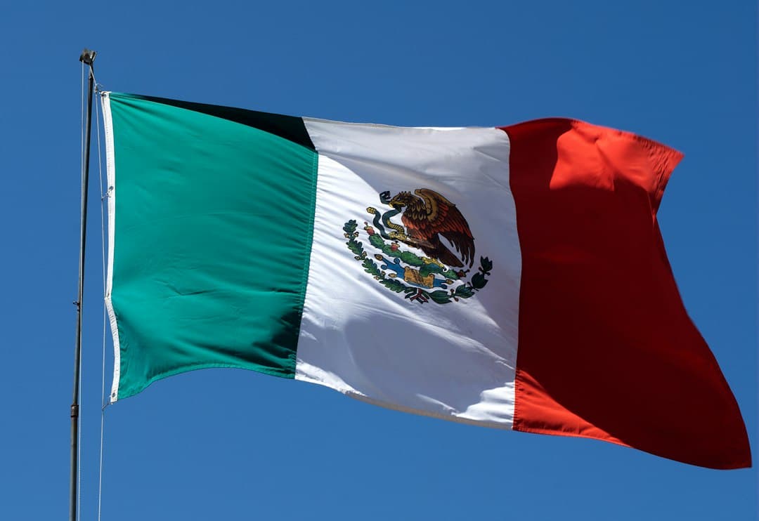 Bandera ondeando al viento con el cielo azul de fondo, en el chat de Miguel Alemán