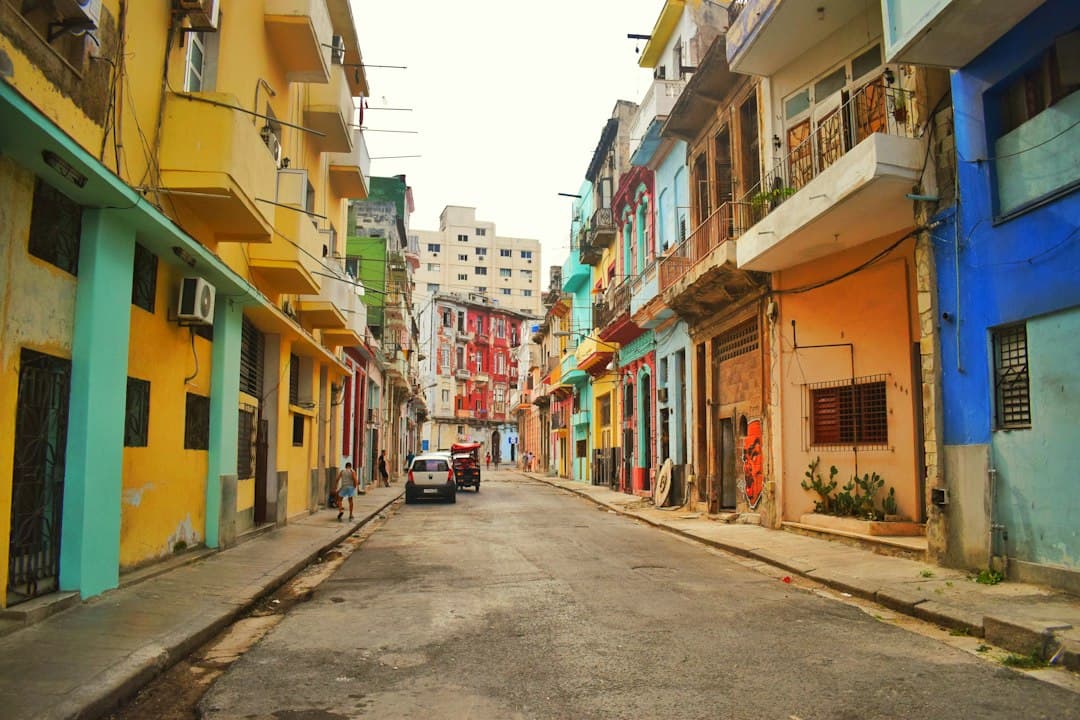 Calle de edificios antiguos de colores con coches clásicos, en el chat de Candelaria
