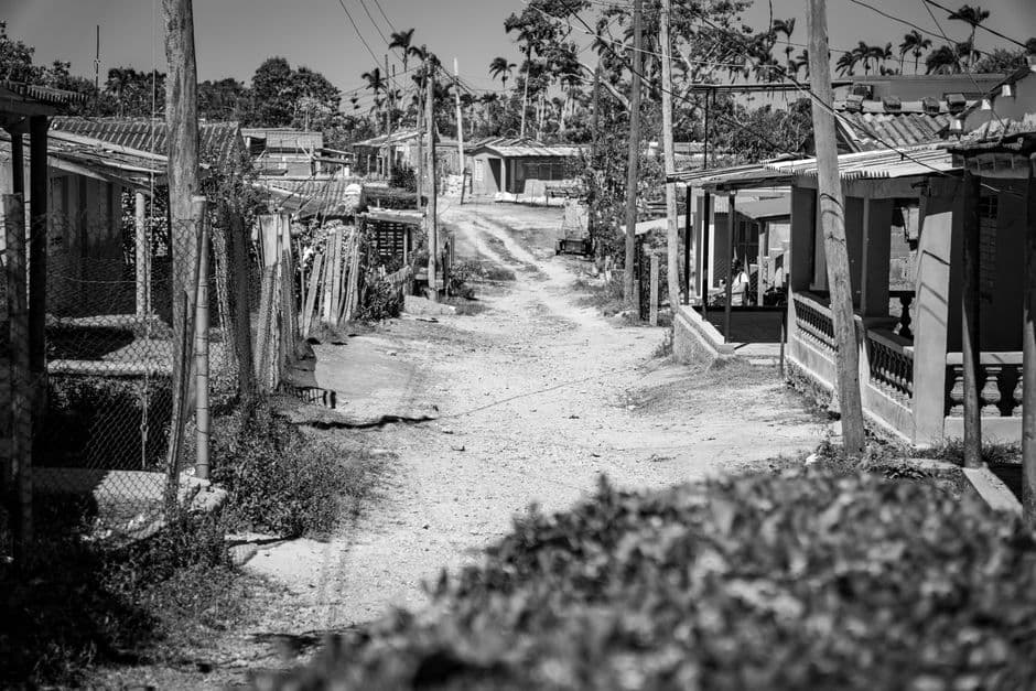Camino de tierra entre las casas de un pueblo tropical, en el chat de Quisqueya