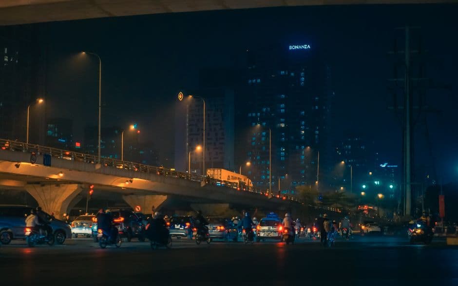 Vehículos cruzan una carretera iluminada bajo la noche, en la sala de chat de Bonanza