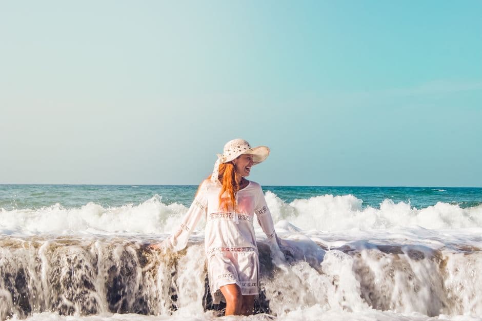 Mujer disfrutando de las olas en una playa, en el chat de Macuto
