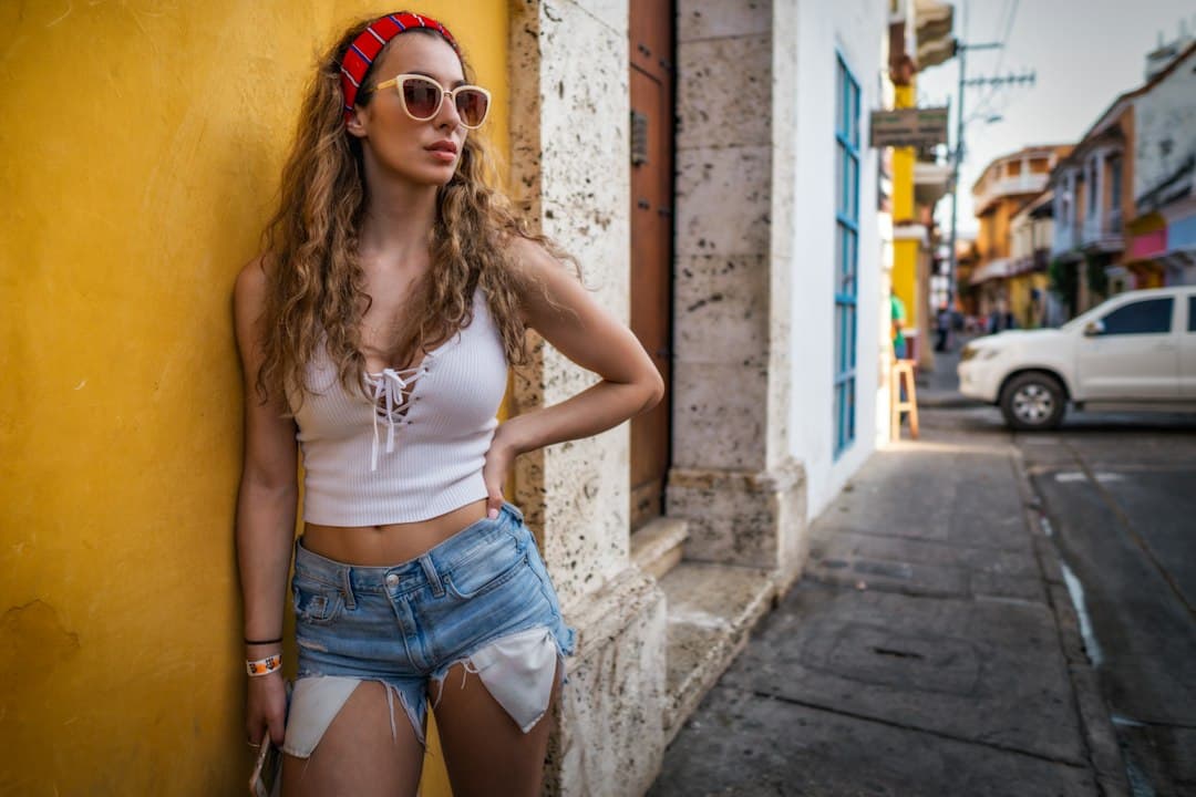 Mujer de pie junto a una pared cerca de un coche, en el chat de Astrea
