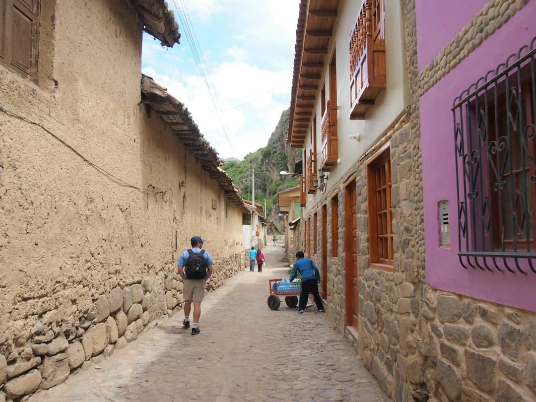 Personas caminando por un pasaje entre casas de hormigón de día, en el chat de Coishco