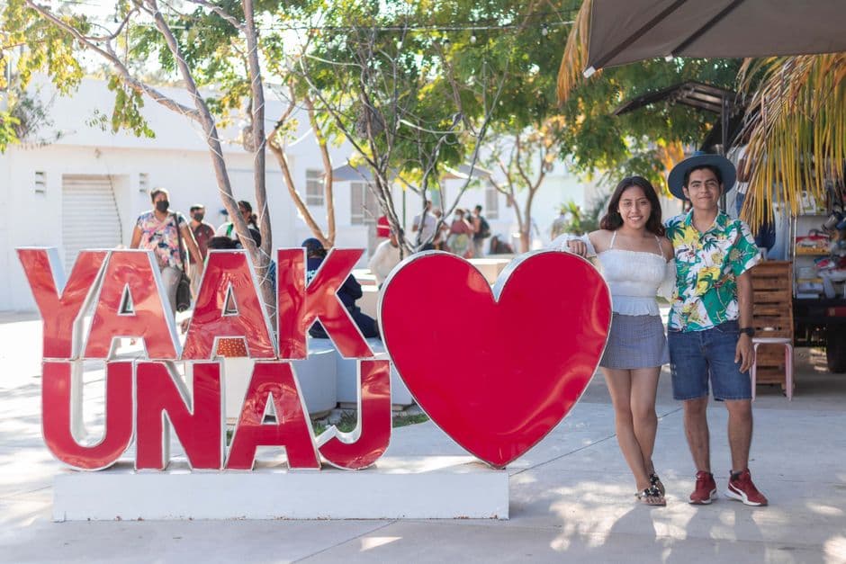 Pareja junto a unas letras con un corazón en un pueblo, en el chat de Yanga