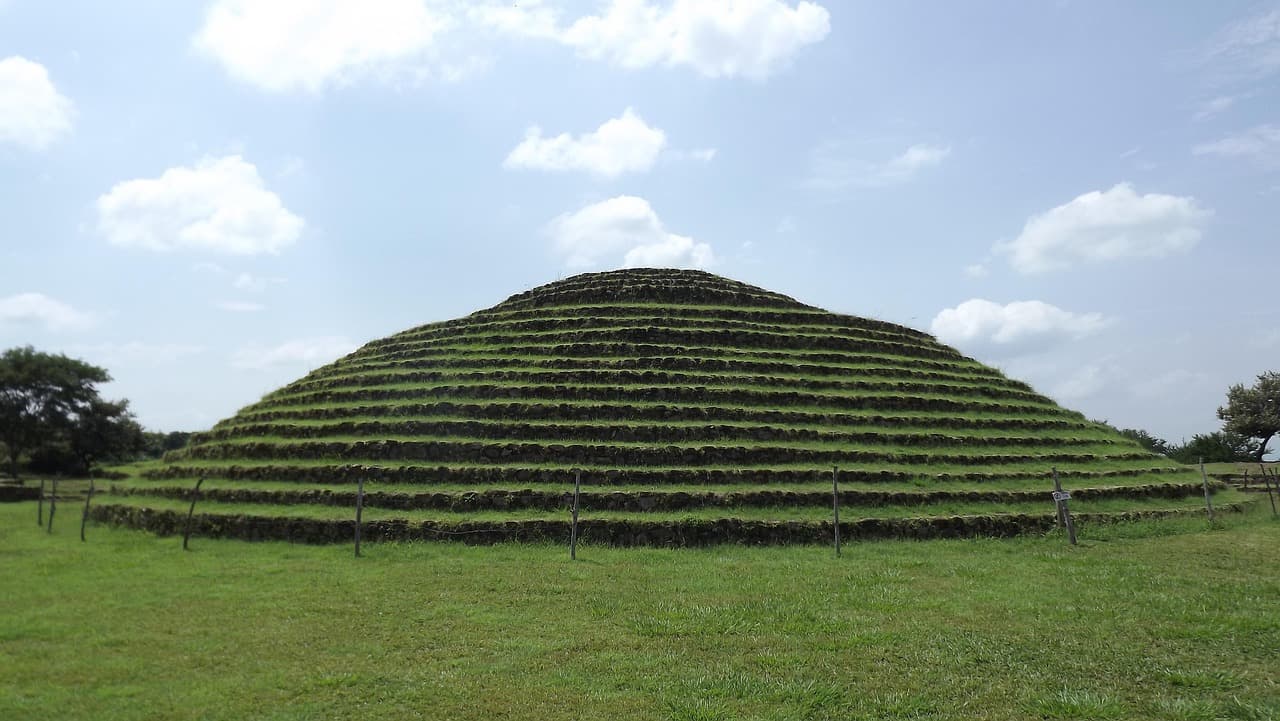 Piramides de piedra sobre llanura verde con montañas al fondo, en el chat de Cuquío