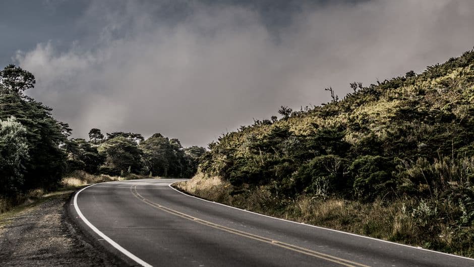 Carretera curva de hormigón junto a la hierba, en el chat de Llanos de Santa Lucía