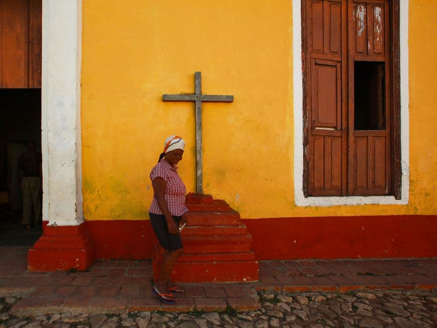 Mujer caminando frente a una iglesia, en el chat de La Trinidad